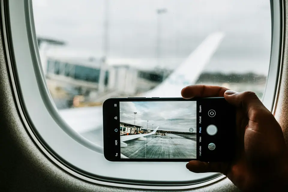 在飛機上用手機拍窗外機翼｜<a href="https://unsplash.com/photos/black-iphone-capturing-plane-wing-d69sz3WCNZg" target="_blank" rel="noopener">Unsplash 原圖</a>