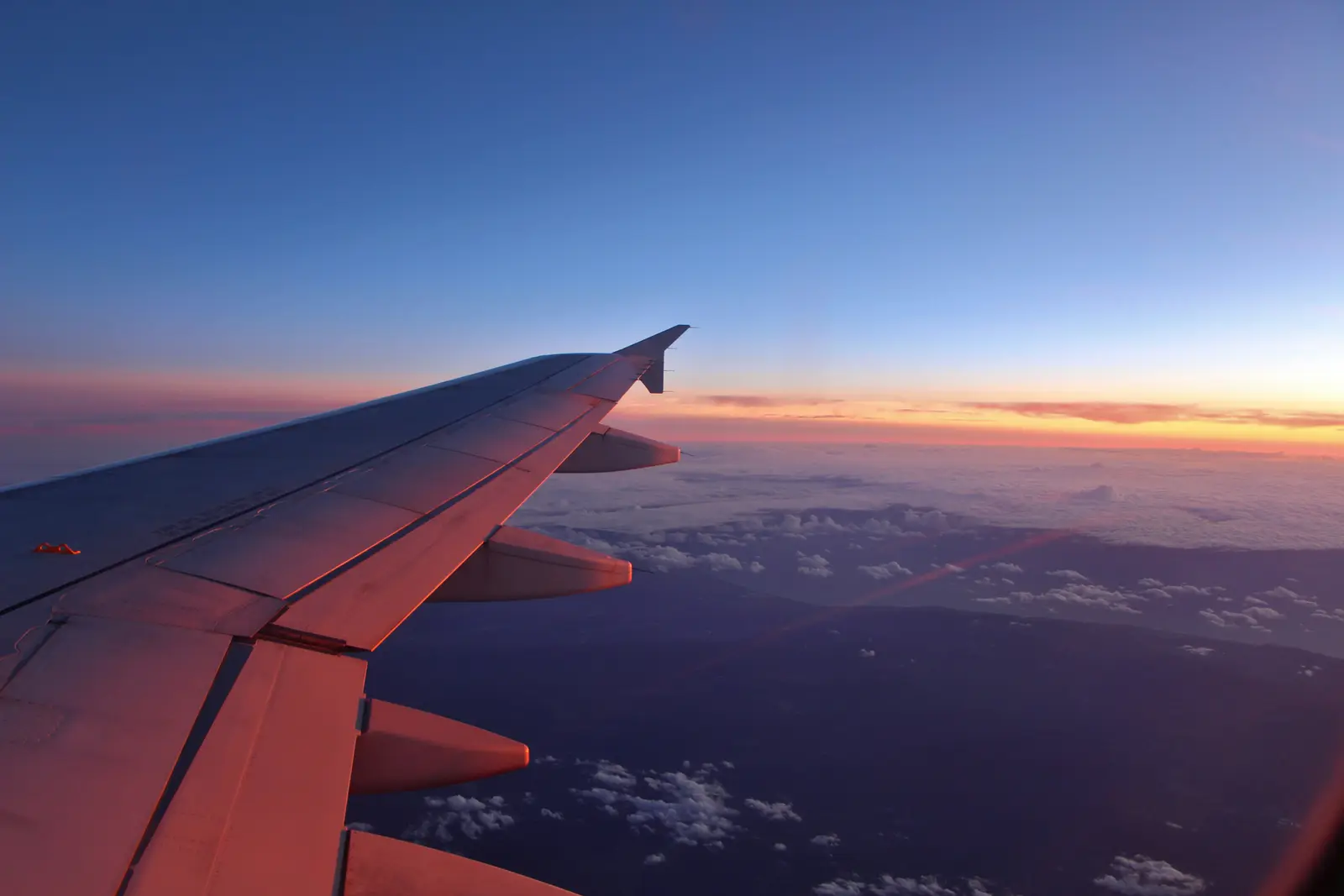 夕陽下從飛機窗外看出去的機翼與雲海｜<a href="https://unsplash.com/photos/a-view-of-the-wing-of-an-airplane-at-sunset-bcGNFkRU7nA" target="_blank" rel="noopener">Unsplash 原圖</a>