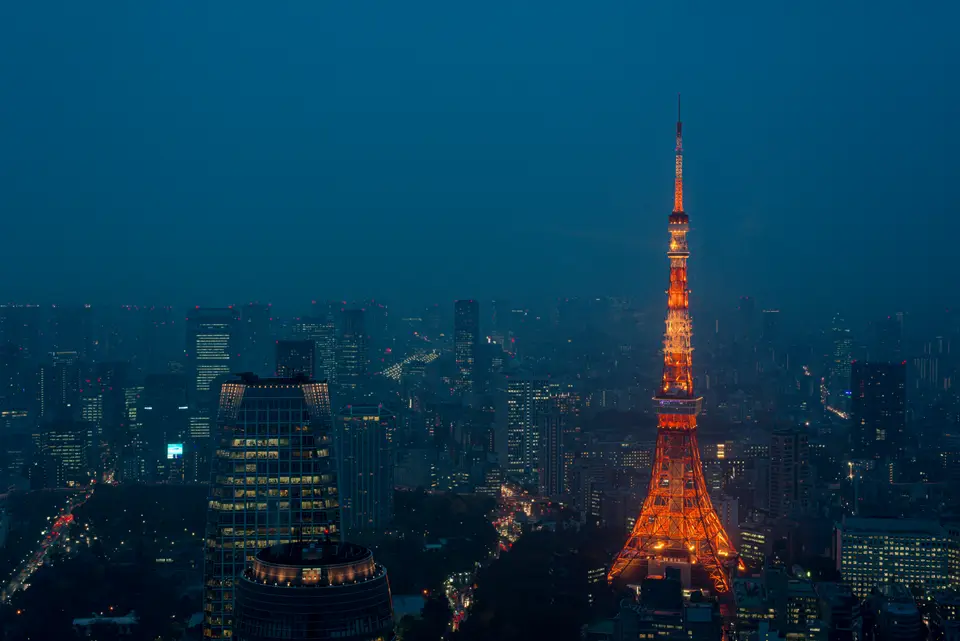 東京鐵塔在藍色夜幕裡亮著橘光｜<a href="https://unsplash.com/photos/tokyo-tower-at-night-in-tokyo-3-esk8zPwPY" target="_blank" rel="noopener">Unsplash 原圖</a>